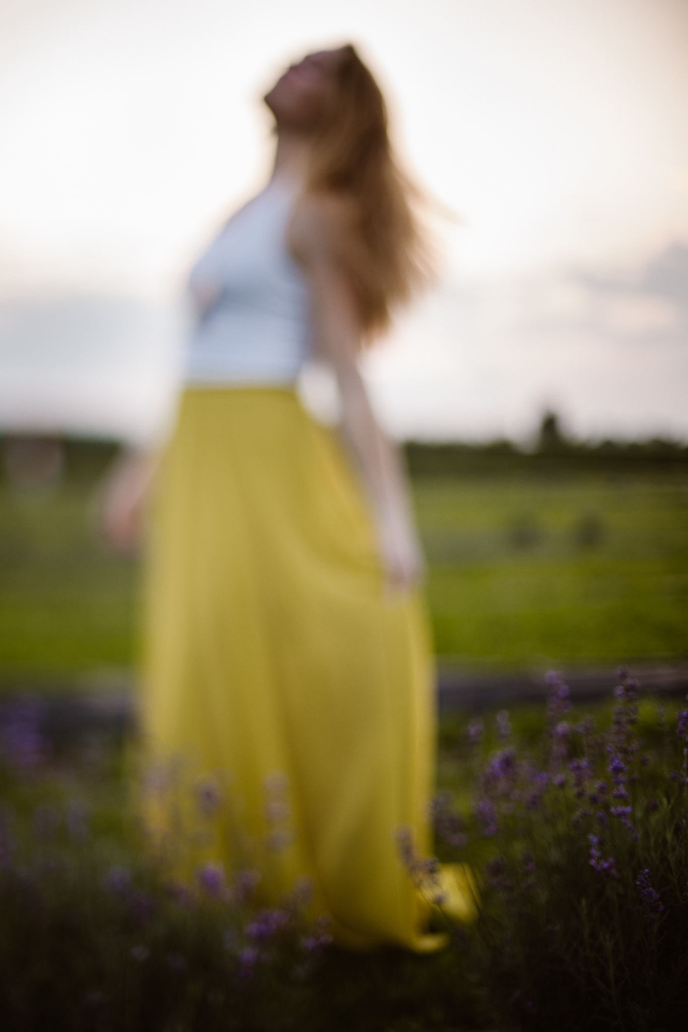 Red headed woman in yellow skirt at sunset in a lavender field.